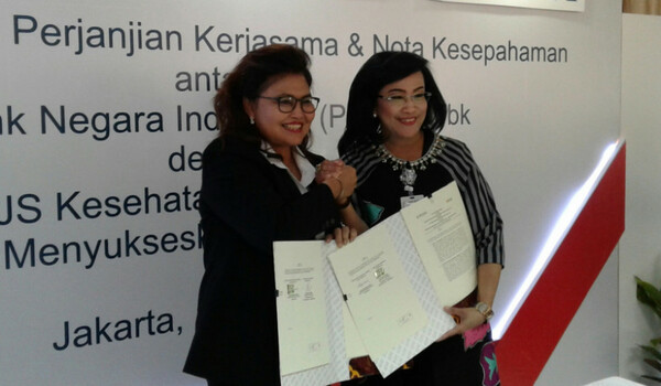 Direktur Kepesertaan dan Pemasaran BPJS Kesehatan Andayani Budi Lestari (kiri), bersama Direktur Hubungan Kelembagaan dan Transaksional Perbankan BNI Adi Sulistyowati (kanan), usai melakukan penandatanganan MoU pemanfaatan layanan keagenan BNI dalam program Kader JKN-KIS, di Jakarta, 10 April 2017