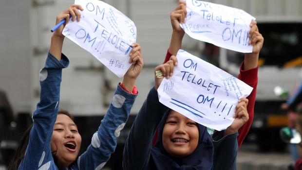 Anak sekolah menuliskan pesan "Om Telolet Om" agar pengemudi bus membunyikan klakson di Jalan Sudirman, Bekasi, Jawa Barat, Rabu 21 Desember 2016. 