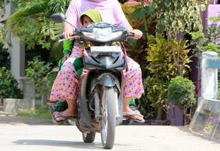 A young mother takes her daughter to school on a motorcycle in Menoro on April 19, 2017. Child marriage is one of the main causes of school dropouts in the area. (JG Photo/Yudhi Sukma Wijaya)