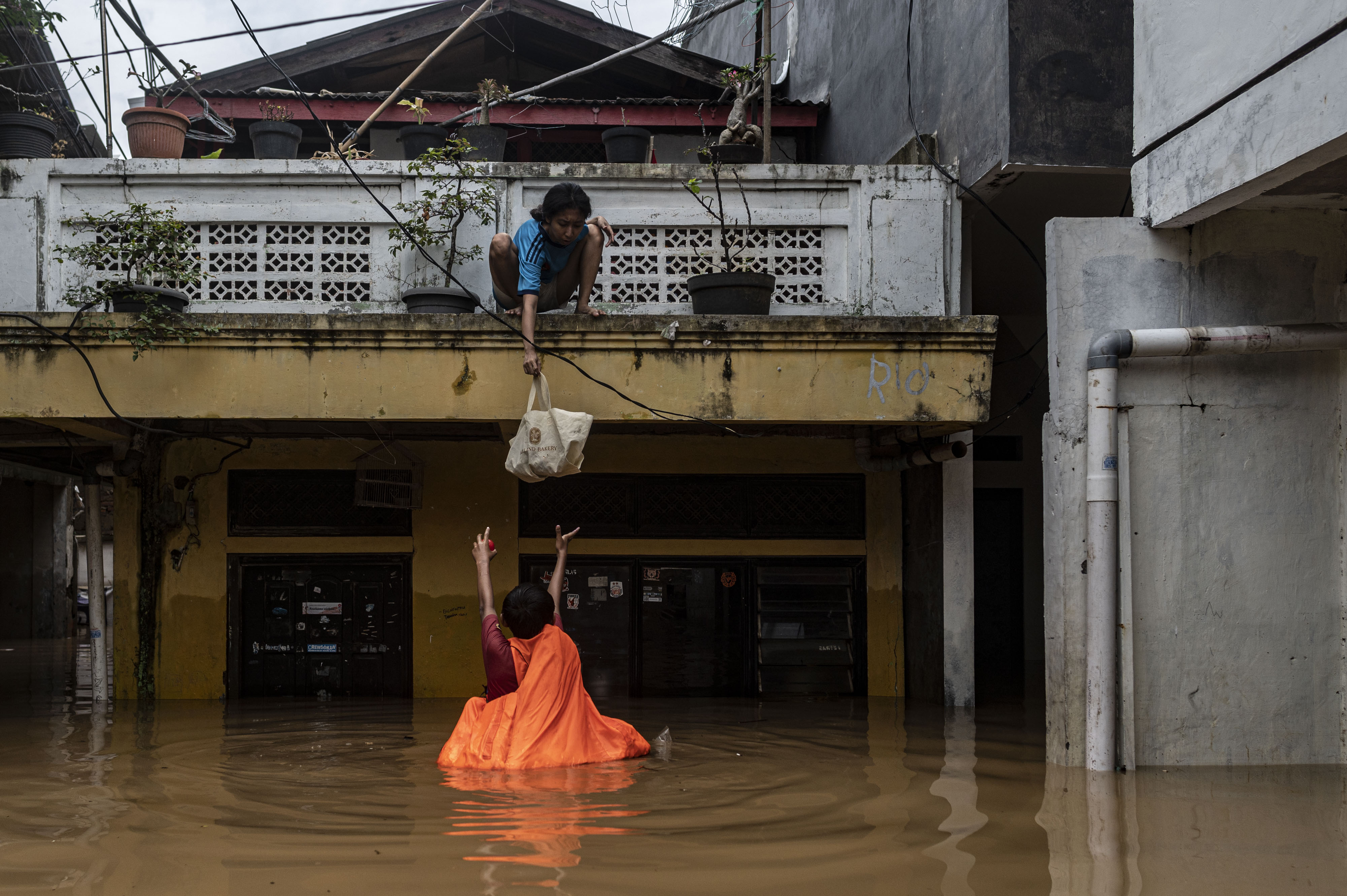 Warga menurunkan barang saat banjir di permukiman penduduk kawasan Rawajati, Jakarta, Senin, 10 Oktober 2022.