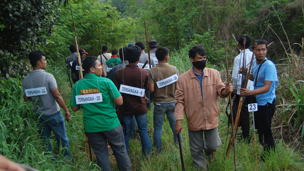 Sejumlah anggota kepolisian berpakaian preman membawa parang, panah dan 2 pucuk senjata yang merupakan barang bukti kejahatan pada rekonstruksi peristiwa Nafri di Pegunungan Nafri, Jayapura, Papua, Senin (10/10). Rekonstruksi Nafri merupakan peristiwa penyerangan oleh kelompok separatis bersenjata pada 4 Agustus lalu, yang dipimpin Dani Kogoya, mengakibatkan tiga warga sipil dan seorang anggota TNI tewas.