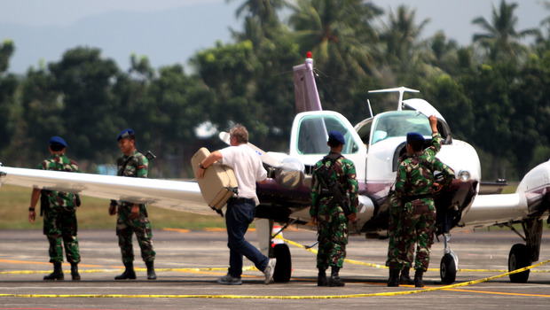 Beberapa personel TNI AU mengawal pilot asing asal Australia yang pesawatnya dipaksa mendarat oleh jet tempur Sukhoi di Pangkalan Udara Sam Ratulangi, Manado, Sulawesi Utara, Rabu (22/10).