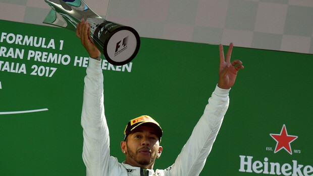 Pembalap Mercedes, Lewis Hamilton, mengangkat trofi yang diraihnya setelah menjuarai balap Formula 1 dalam Grand Prix Italia di Sirkuit Monza, Minggu, 3 September 2017.