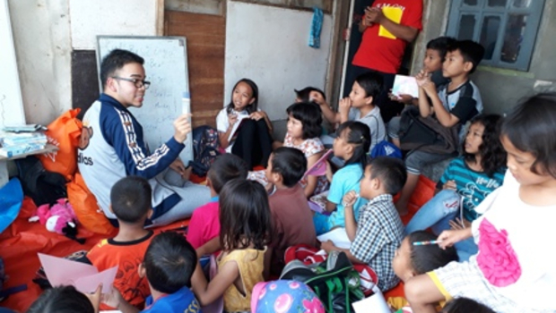Abraham Michael (kaca mata tengah) sedang mengajar Bahasa Inggris anak-anak Kampung Tanah Merah, Rawa Badak Selatan, Koja, Jakarta Utara, Minggu (8/4).  