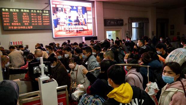 Penumpang mengantre untuk masuk ke dalam kereta di Stasiun Kereta Jiujiang, kota yang terletak di perbatasan Provinsi Jiangxi dan Hubei, yang merupakan episentrum penyebaran Covid-19, Rabu, 18 Maret 2020.