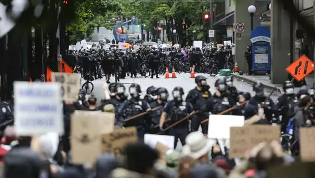 Polisi memblokir jalan dalam aksi unjuk rasa kematian George Floyd, seorang pria kulit hitam oleh petgas Kepolisian Minneapolis, di Seattle, Washington pada 30 Mei 2020.
