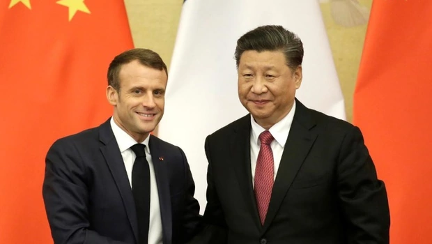 Presiden Prancis, Emmanuel Macron (kiri), berjabat tangan dengan Presiden Tiongkok, Xi Jinping, di Aula Besar Rakyat Beijing, saat berkujung ke Tiongkok, pada Desember 2019. 