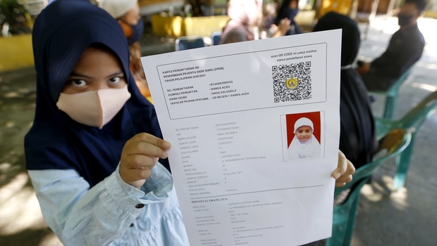 Calon pelajar Sekolah Dasar (SD) memperlihatkan formulir PPDB sesuai zona saat mendaftar ulang di SD Negeri 1 Banda Aceh, Aceh, Selasa, 9 Juni 2020. 