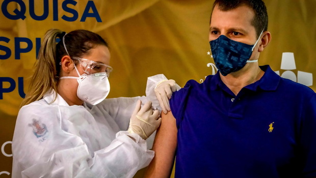 Pekerja kesehatan dan sukarelawan Luciano Marini menerima vaksin Covid-19 yang diproduksi oleh perusahaan China Sinovac Biotech di Rumah Sakit Sao Lucas, di Porto Alegre, Brasil selatan, Sabtu (8/8/2020).