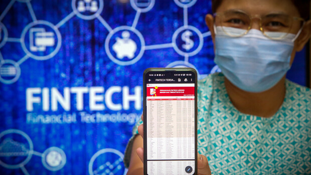 Karyawan mengakses informasi perusahaan Fintech Lending yang terdaftar di Otoritas Jasa Keuangan (OJK) pada perangkat smartphone di Jakarta, Jumat (2/10/2020). 