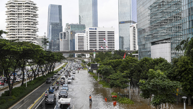 Sejumlah pengendara melintasi banjir di kawasan Jalan Jenderal Sudirman, Jakarta, Sabtu, 20 Februari 2021. Intensitas hujan yang tinggi serta buruknya drainase menyebabkan banjir di sejumlah wilayah Ibu Kota.