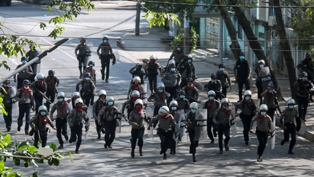 Polisi berlari ke arah pengunjuk rasa untuk membubarkan demonstrasi yang diadakan menentang kudeta militer di Yangon, Kamis (3/3/2021).
