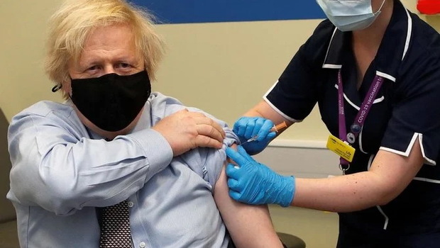 Perdana Menteri Inggris Boris Johnson disuntik dengan vaksin Covid-19 Astrazeneca / Oxford yang diberikan oleh perawat Lily Harrington, di pusat vaksinasi di Rumah Sakit St. Thomas, London, Inggris, Jumat 19 Maret 2021. 