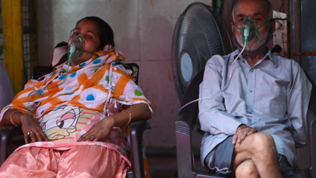 Pasien bernapas dengan bantuan oksigen yang disediakan oleh Gurudwara (Kuil Sikh) di bawah tenda yang dipasang di sepanjang pinggir jalan ketika pandemi virus corona Covid-19 melanda di Ghaziabad, India pada Selasa 4 Mei 2021. 