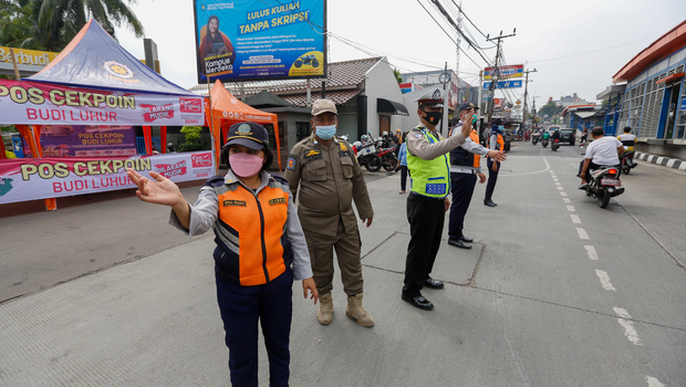 Petugas gabungan mengatur arus lalu lintas saat hari pertama penyekatan larangan mudik di perbatasan Jakarta-Tangerang, Jalan Ciledug Raya, Jakarta, Kamis, 6 Mei 2021.