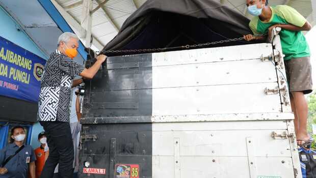 Gubernur Jawa Tengah Ganjar Pranowo memanjat truk untuk mengecek muatan truk di Ajibarang, Banyumas, Jumat 7 Mei 2021.
