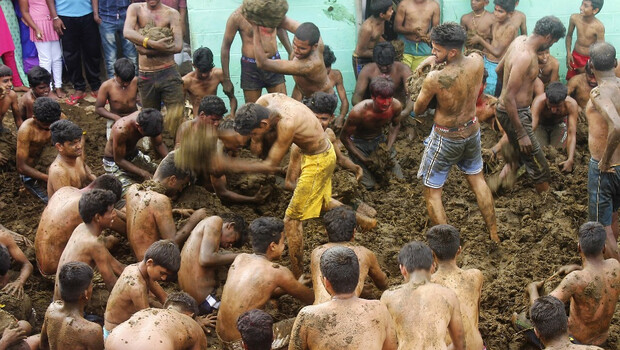 Foto dokumentasi pada 17 November 2020 ini memperlihatkan orang-orang mengambil bagian dalam festival Gorehabba atau mandi kotoran sapi di desa Gumatapura, perbatasan negara bagian Karnataka dan Tamil Nadu di India. 