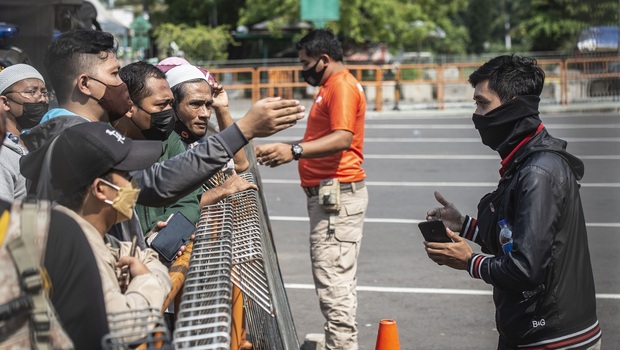 Petugas memberikan imbauan kepada warga yang akan berwisata untuk kembali pulang di depan pintu masuk Ancol Taman Impian, Jakarta, Sabtu, 15 Mei 2021.