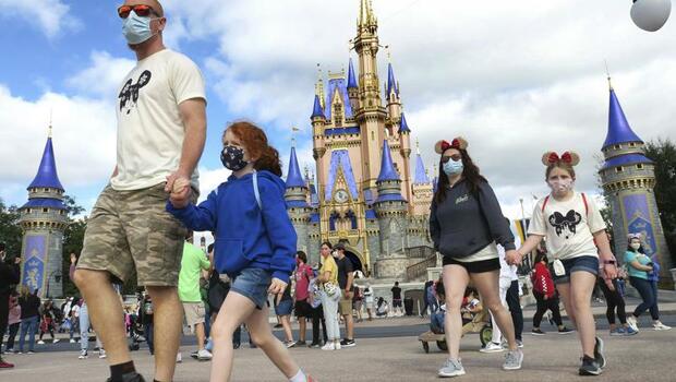 Para pengunjung Disneyland di Florida, Amerika Serikat, mengenakan masker saat berwisata.