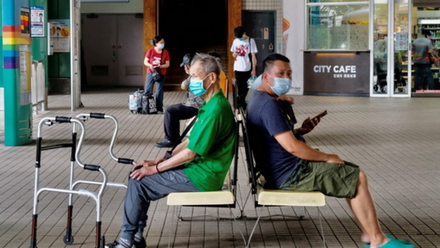 Penduduk lokal, yang mengenakan masker wajah setelah Taiwan meningkatkan tingkat kewaspadaannya di beberapa lokasi setelah gelombang baru infeksi virus corona Covid-19, menunggu bus di Bitan - tempat pemandangan populer - di New Taipei City, Taiwan pada Sabtu 15 Mei 2021.