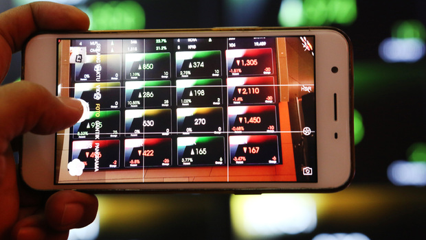 Pengunjung memotret monitor indeks saham mengunakan ponsel di Bursa Efek Indonesia (BEI), Jakarta.