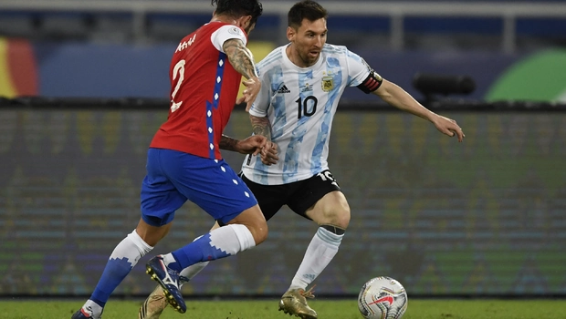 Striker Argentina, Lionel Messi (kanan), merupaya melewati adangan bek Cile, Eugenio Mena dalam partai Copa America.