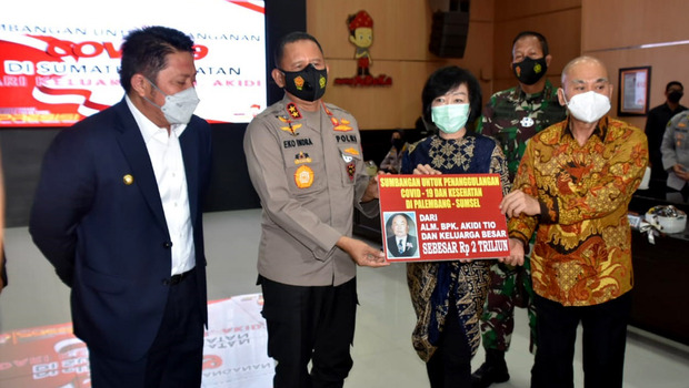 Gubernur Sumsel Herman Deru (kiri) dan  Kapolda Sumsel Irjen Pol Eko Indra Heri (kedua kiri) menerima bantuan penanganan Covid-19 Rp 2 triliun secara simbolis dari keluarga Akidi Tio di Mapolda Sumsel, Palembang, Senin 26 Juli 2021.
