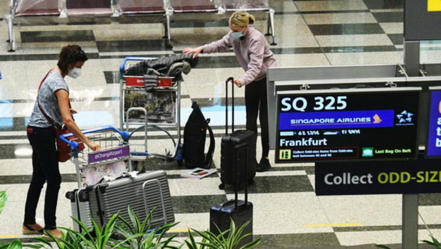 Para pelancong dengan penerbangan Singapore Airlines SQ325 mengambil bagasi di ruang bagasi di Bandara Changi, Singapura pada Rabu 8 September 2021. 