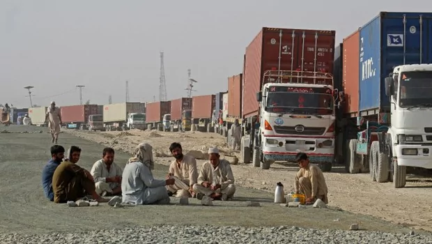 Para pengemudi duduk di dekat truk kontainer mereka saat mereka menunggu untuk memasuki Afghanistan di kota perbatasan Pakistan, Chaman. 