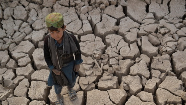 Seorang anak berdiri di tanah kering di distrik Bala Murghab, provinsi Badghis, Afghanistan. Kekeringan melanda ladang kering di sekitar distrik terpencil Bala Murghab di Afghanistan, tempat perubahan iklim terbukti menjadi musuh yang lebih mematikan daripada konflik negara baru-baru ini. 