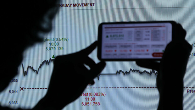 Investor memotret pergerakan saham menggunakan telpon seluler di Jakarta.