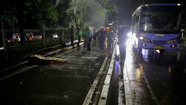 Sejumlah warga dan pengguna jalan menunggu mobil ambulance untuk evakuasi korban yang menjadi korban kecelakaan tertabrak bus Transjakarta di kawasan Jalan Margasatwa, Pasar Minggu, Jakarta Selatan, Senin 6 Desember 2021 malam. 