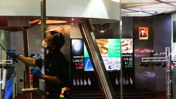 Petugas membersihkan kaca di depan layar monitor Bursa Efek Indonesia (BEI), Jakarta.