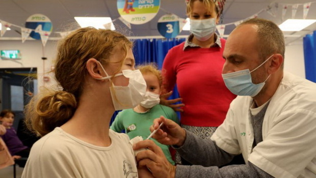 Seorang anak menerima dosis vaksin Covid-19 di kota Modiin, Israel tengah, pada Rabu 15 Desember 2021. Kementerian Kesehatan Israel melarang perjalanan ke tujuh negara lagi untuk mencegah penyebaran varian Omicron Covid-19.