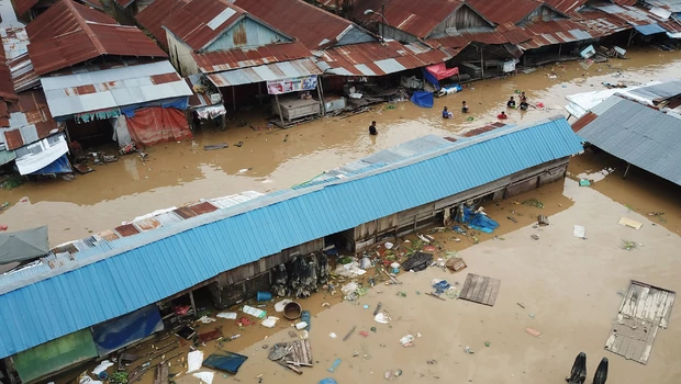 Warga berjalan menembus banjir di Pasar Youtefa Abepura, Jayapura, Papua, Jumat, 7 Januari 2022.