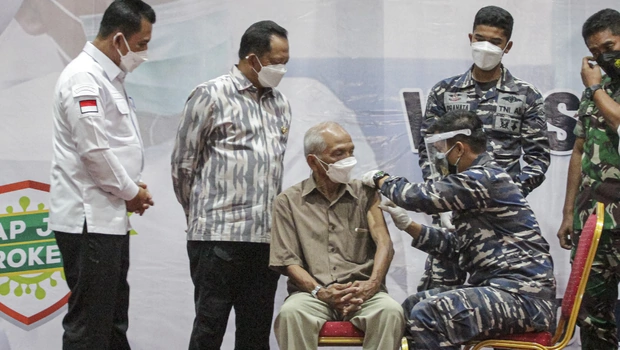 Menteri Dalam Negeri Tito Karnavian (kedua kiri) bersama Gubernur Kepulauan Riau Ansar Ahmad (kiri) menyaksikan pemberian vaksinasi lanjutan (booster) kepada seorang lansia di Vihara Duta Maitreya Monastery, Batam, Kepulauan Riau, Kamis, 13 Januari 2022. 