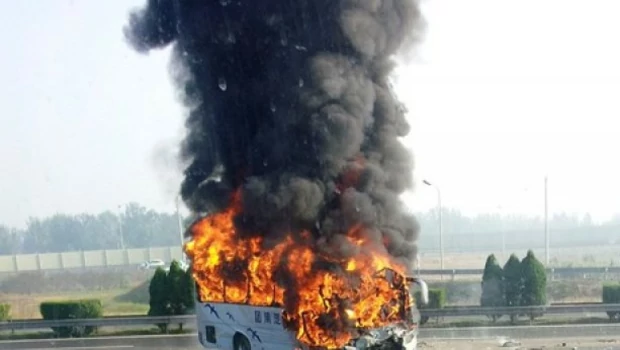 Sebuah bus wisata terbakar setelah bertabrakan dengan sebuah truk di Jalan Tol Beijing-Tianjin-Tanggu, Tianjin, Tiongkok, pada 1 Oktober 2012.