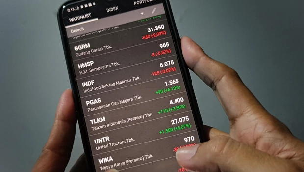 Investor memantau pergerakan saham melalui layar smartphone.