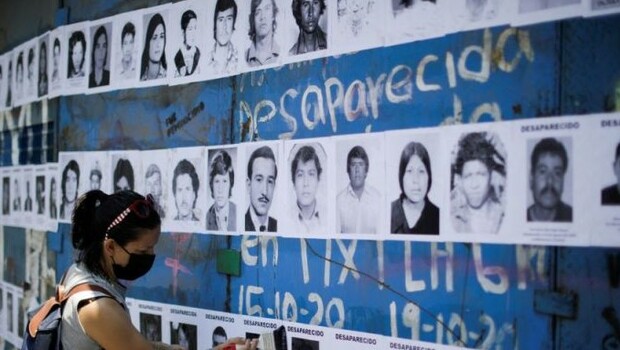 Seorang warga memasang foto kerabat yang hilang di Mexico City, 15 Mei 2022.