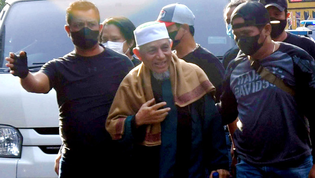 Pimpinan Khilafatul Muslimin, Abdul Qadir Baraja (tengah) saat tiba di Polda Metro Jaya, Jakarta, Selasa, 7 Juni 2022.