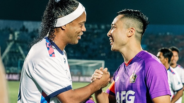 Ronaldinho yang memperkuat Rans Nusantara (kiri) bersalaman dengan pemain Persik Kediri, Arthur Irawan.