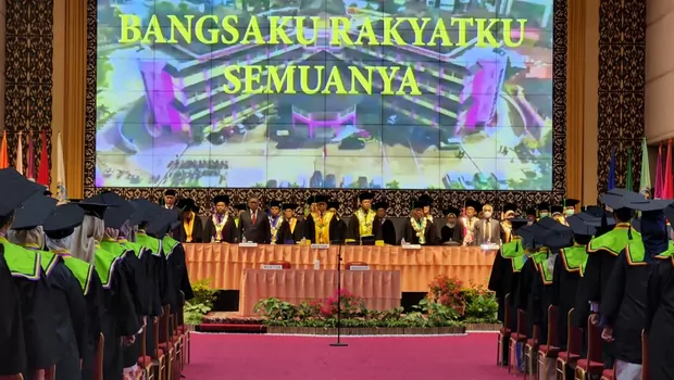 Para wisudawan Universitas Negeri Padang menyanyikan lagu kebangsaan Indonesia Raya dalam prosesi wisuda di Aula kampus tersebut, Minggu, 3 Juli 2022.