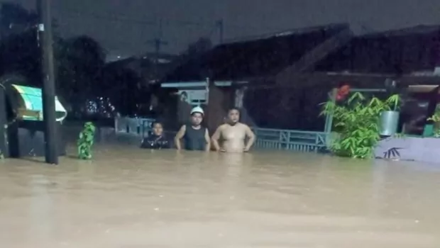 Sejumlah warga berjalan melewati genangan banjir di Perumahan Bumi Pesanggrahan Indah (BPI) di Desa Cilebut Barat, Sukaraja, Kabupaten Bogor, Jawa Barat, Jumat, 15 Juli 2022.