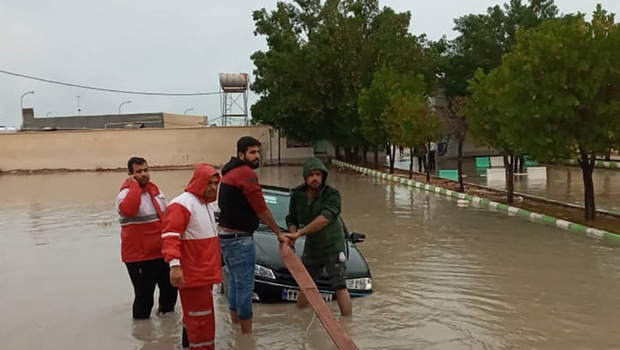 Foto dokumentasi yang disediakan oleh Bulan Sabit Merah Iran pada 4 Januari 2022 menunjukkan para anggota memindahkan kendaraan yang terjebak banjir di Provinsi Hormozgan di selatan Iran.