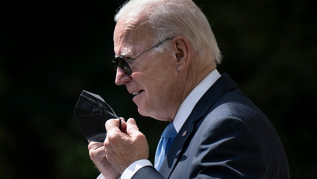 Presiden AS Joe Biden melepas masker pelindungnya saat tiba untuk menyampaikan pidato di Rose Garden Gedung Putih di Washington, DC, AS, pada Rabu 27 Juli 2022.