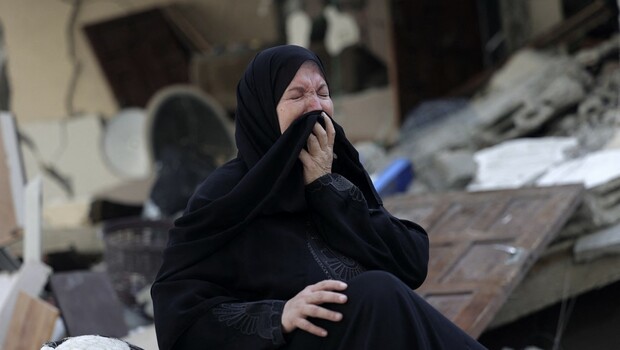 Seorang wanita Palestina berduka di depan puing-puing rumahnya yang hancur selama serangan udara Israel semalam di Kota Gaza, pada 7 Agustus 2022.