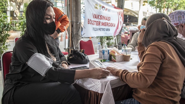 Petugas kesehatan memeriksa kesehatan calon penerima vaksin booster Covid-19 di kawasan Blok M, Jakarta, Minggu 14 Agustus 2022.