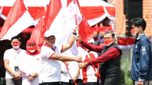 Mendagri Tito Karnavian didampingi Gubernur Jawa Timur, Khofifah Indar Parawansa membagikan bendera merah putih kepada sejumlah elemen masyarakat Gedung Negara Grahadi, Surabaya, Minggu, 14 Agustus 2022.