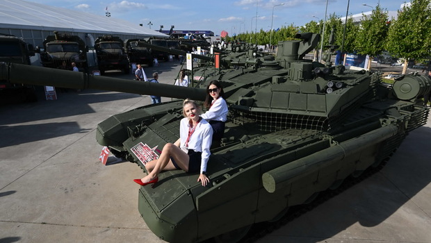 Pemandu pameran berpose di atas tank selama Forum Teknis Militer Internasional Angkatan Darat-2022 di Taman Patriot Angkatan Bersenjata Rusia di Kubinka, pinggiran kota Moskwa, pada Selasa 16 Agustus 2022. 