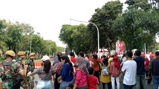 Masyarakat yang melihat pelaksanaan Upacara 17 Agustus dari luar Istana Merdeka. 